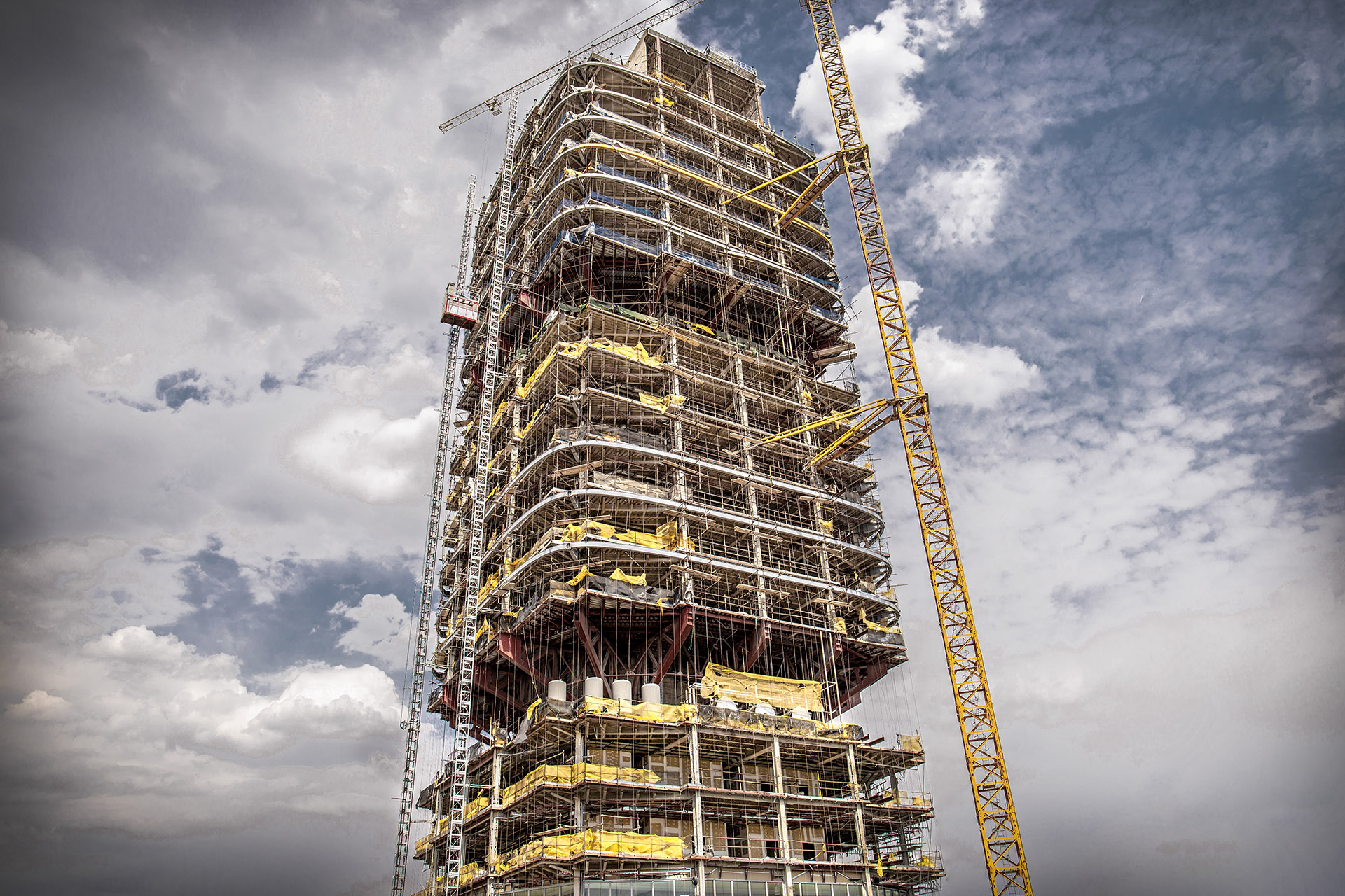 Steel-frame high-rise under construction with tower cranes — captured for long-term timelapse monitoring by Vaavak